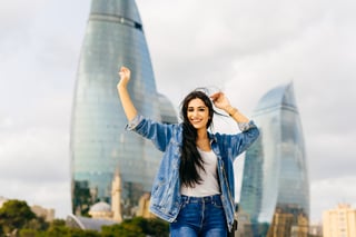attractive young brunette girl laughing posing against a background of modern buildings in the attractive young brunette girl laughing posing against a background of modern buildings in the