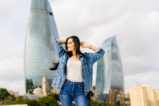 happy stylish black haired girl is walking- along azerbaijan posing against the background