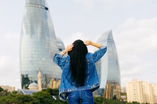 Long Haired Brunette Girl Travels On Vacation Posing Against A Background Of Modern Buildings Long Haired Brunette Girl Travels On Vacation Posing Against A Background Of Modern Buildings