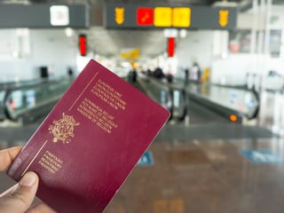 Person Holding A Belgian Passport While Walking In A Airport Terminal Person Holding A Belgian Passport While Walking In A Airport Terminal