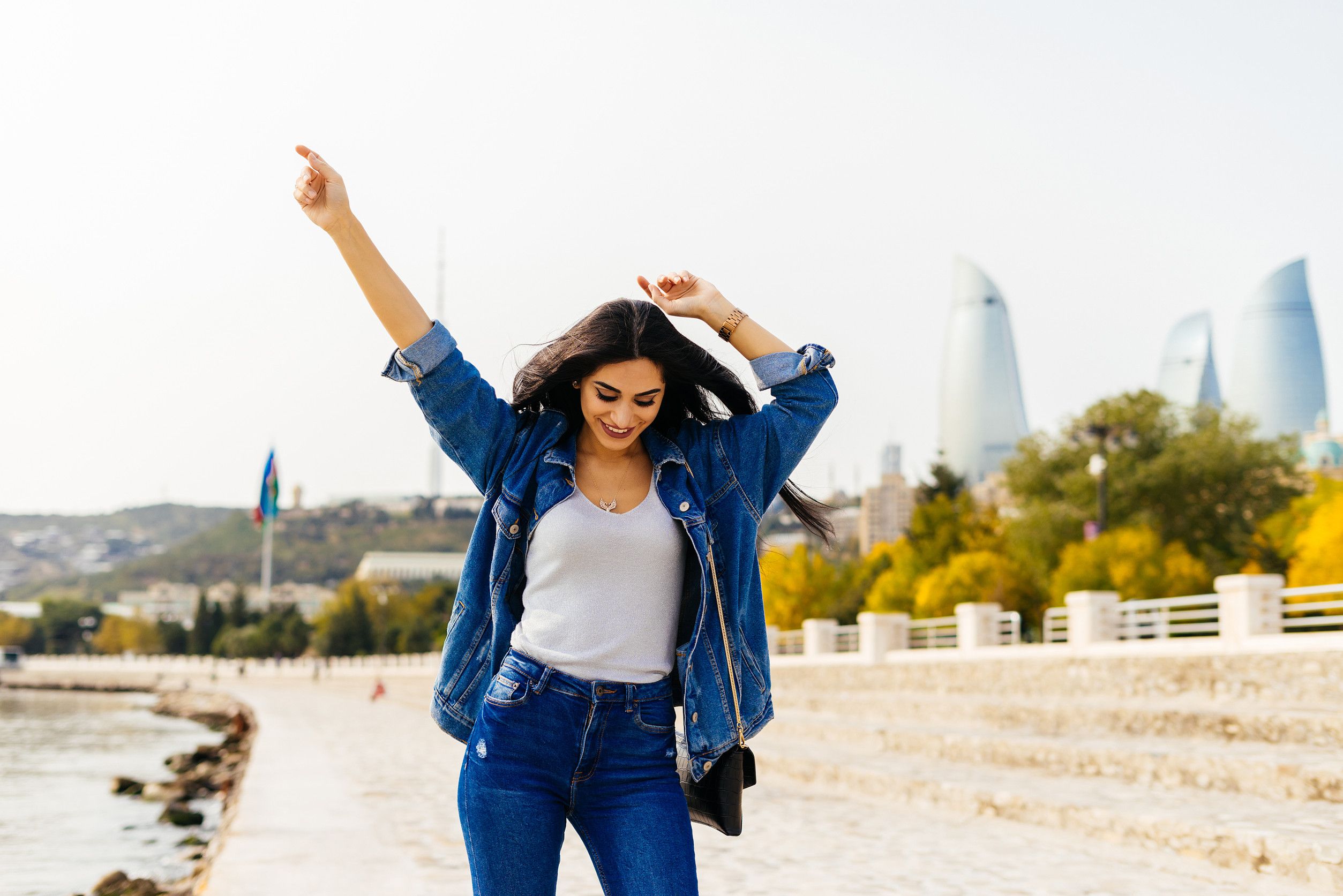 Femme heureuse dans une veste en jean se promenant dans la ville Femme heureuse dans une veste en jean se promenant dans la ville