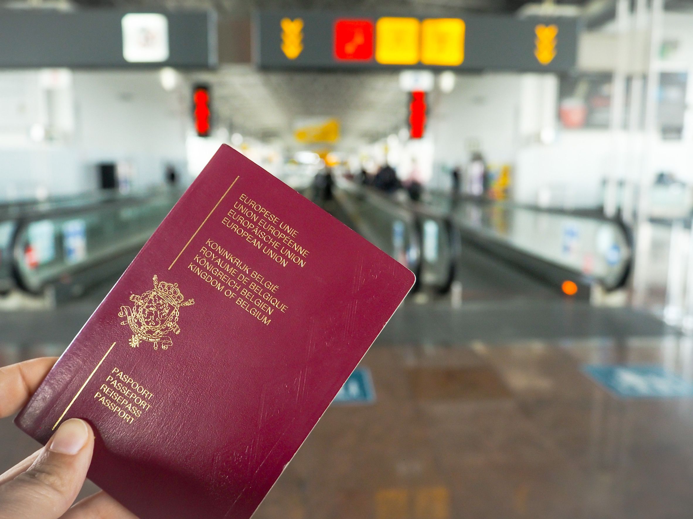 Persona con pasaporte belga caminando por la terminal del aeropuerto Persona con pasaporte belga caminando por la terminal del aeropuerto