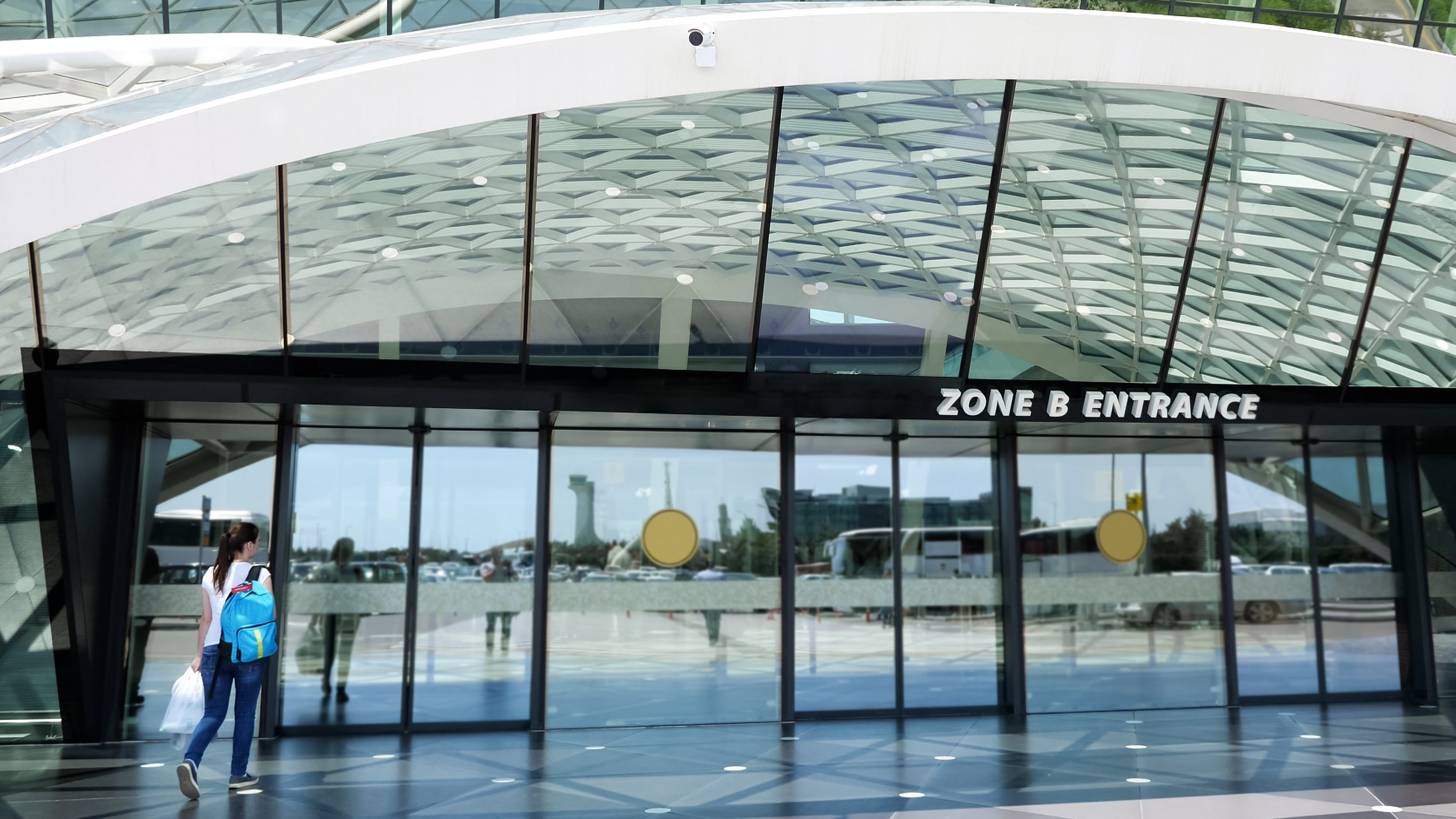 vue à l'entrée de l'aéroport avec une femme entrant par la porte du nouveau terminal d'aéroport moderne vue à l'entrée de l'aéroport avec une femme entrant par la porte du nouveau terminal d'aéroport moderne